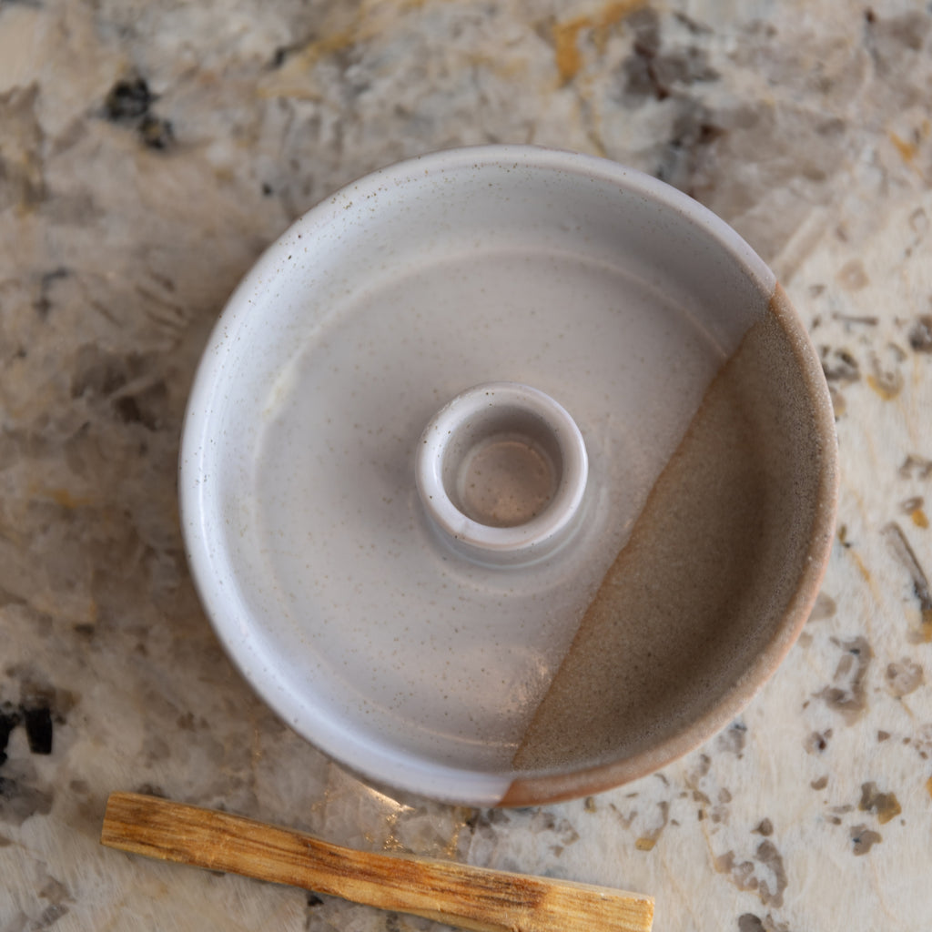 Ceramic container with wooden tool on a textured surface