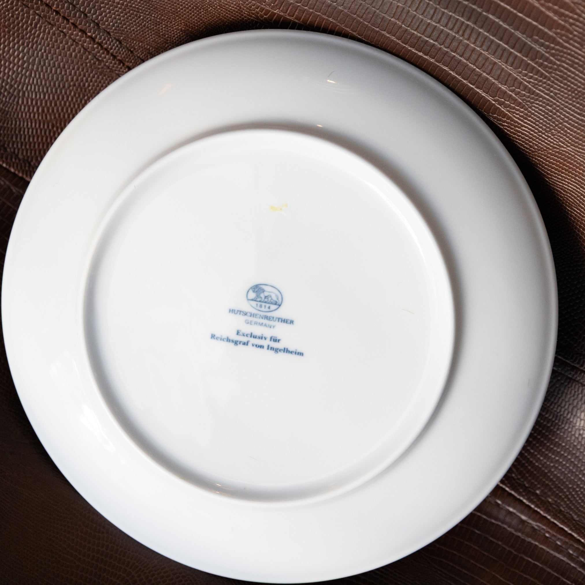 White plate with a logo and text on a brown surface