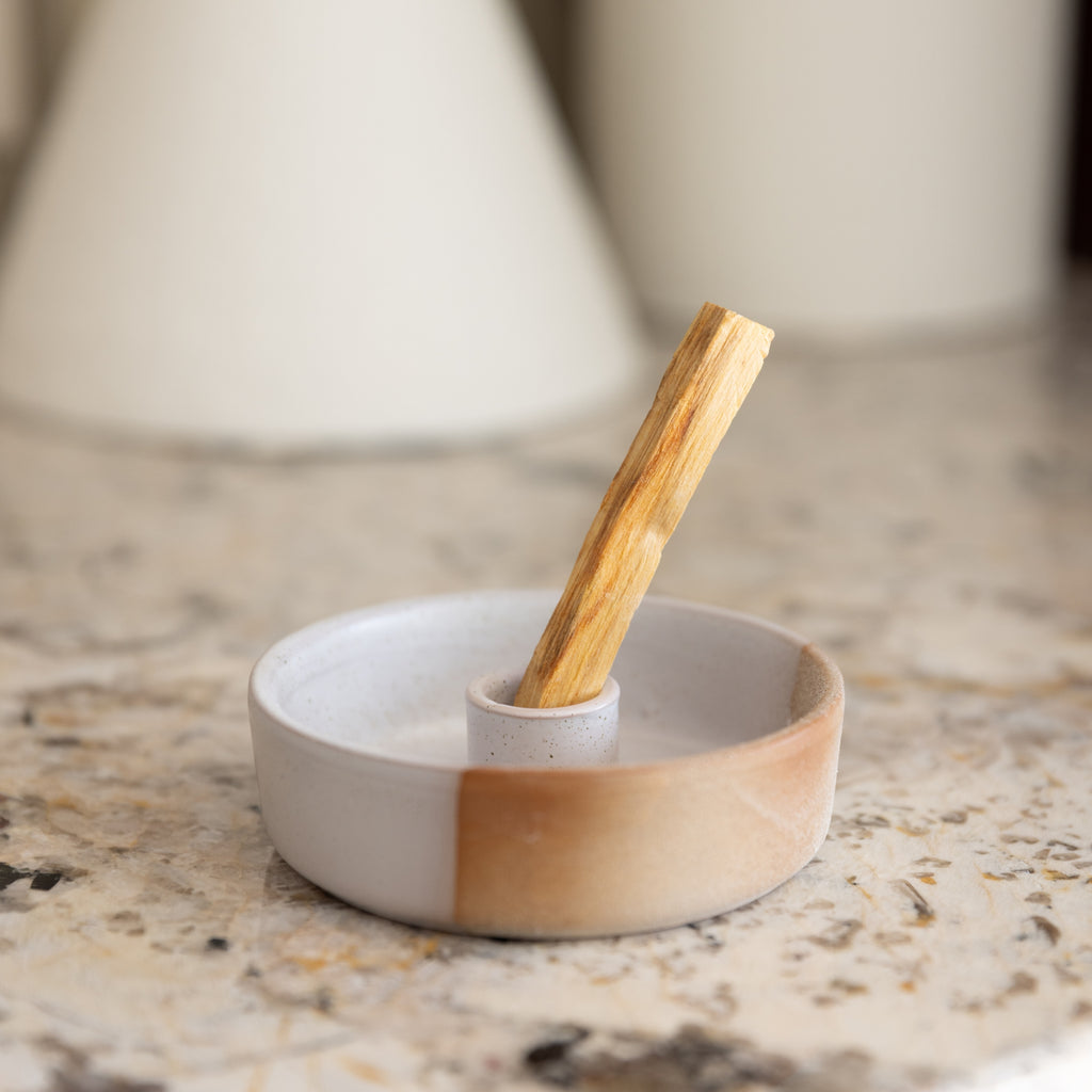 Small ceramic dish with wooden handle on a marble surface