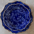 Stack of blue decorative plates with floral patterns on a neutral background