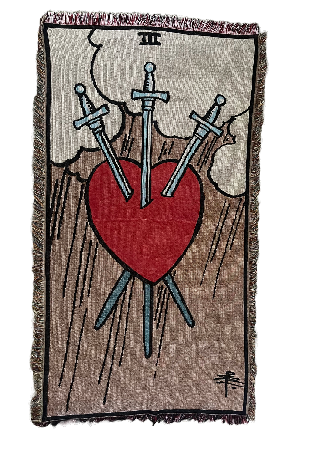 Woven blanket with a heart and swords design, resembling a tarot card, on a beige background.