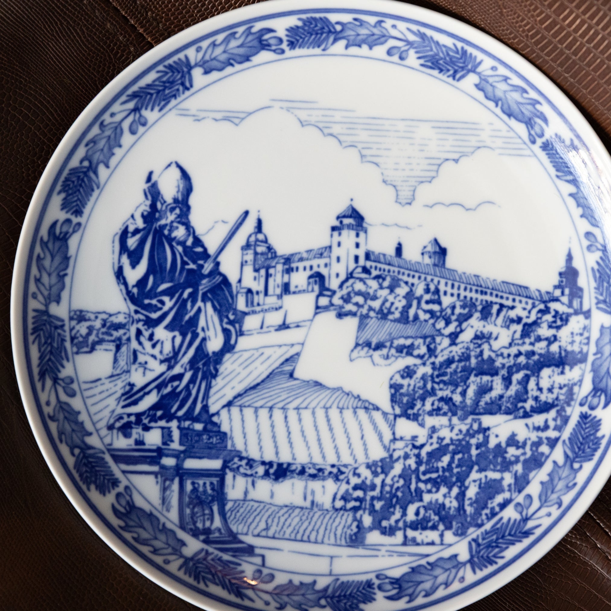 Decorative plate with blue and white design of a statue and castle