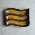 Ceramic dish with wavy design on a marble surface