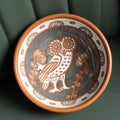 Ceramic bowl with owl design on a dark green background