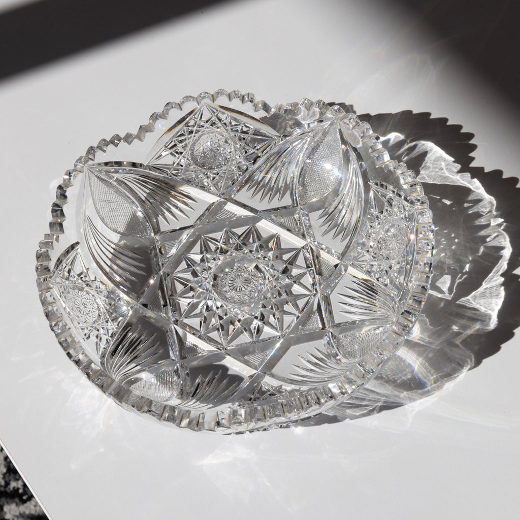 Decorative crystal bowl with intricate cut patterns on a white surface