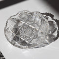 Decorative crystal bowl with intricate cut patterns on a white surface