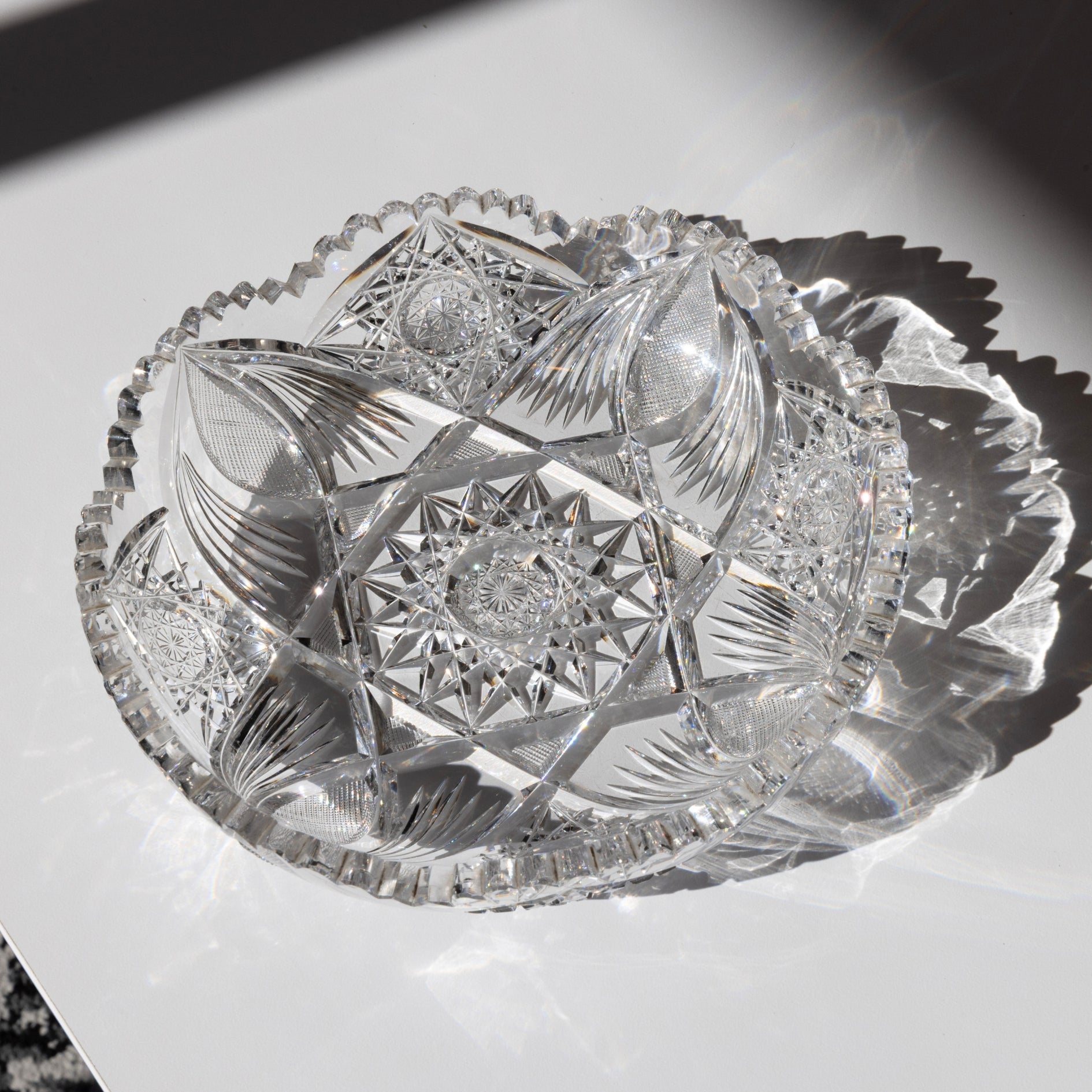 Decorative crystal bowl with intricate cut patterns on a white surface