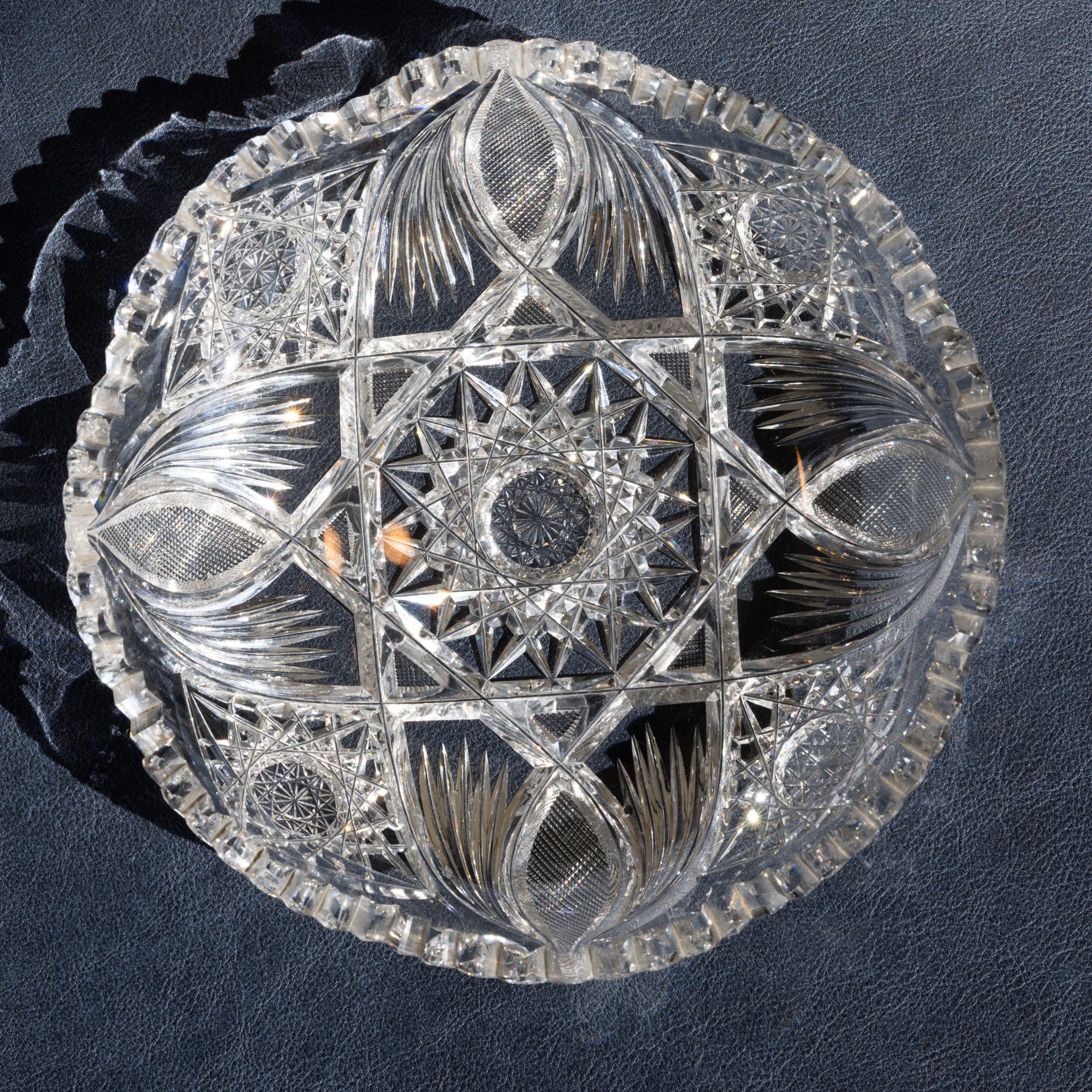 Decorative crystal bowl with geometric patterns on a dark background