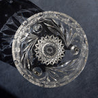 Decorative crystal dish with intricate cut patterns on a dark background