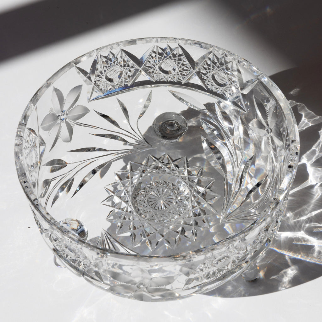 Cut crystal bowl with intricate designs on a reflective surface