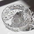 Cut crystal bowl with intricate designs on a reflective surface