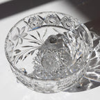 Cut crystal bowl with intricate designs on a reflective surface