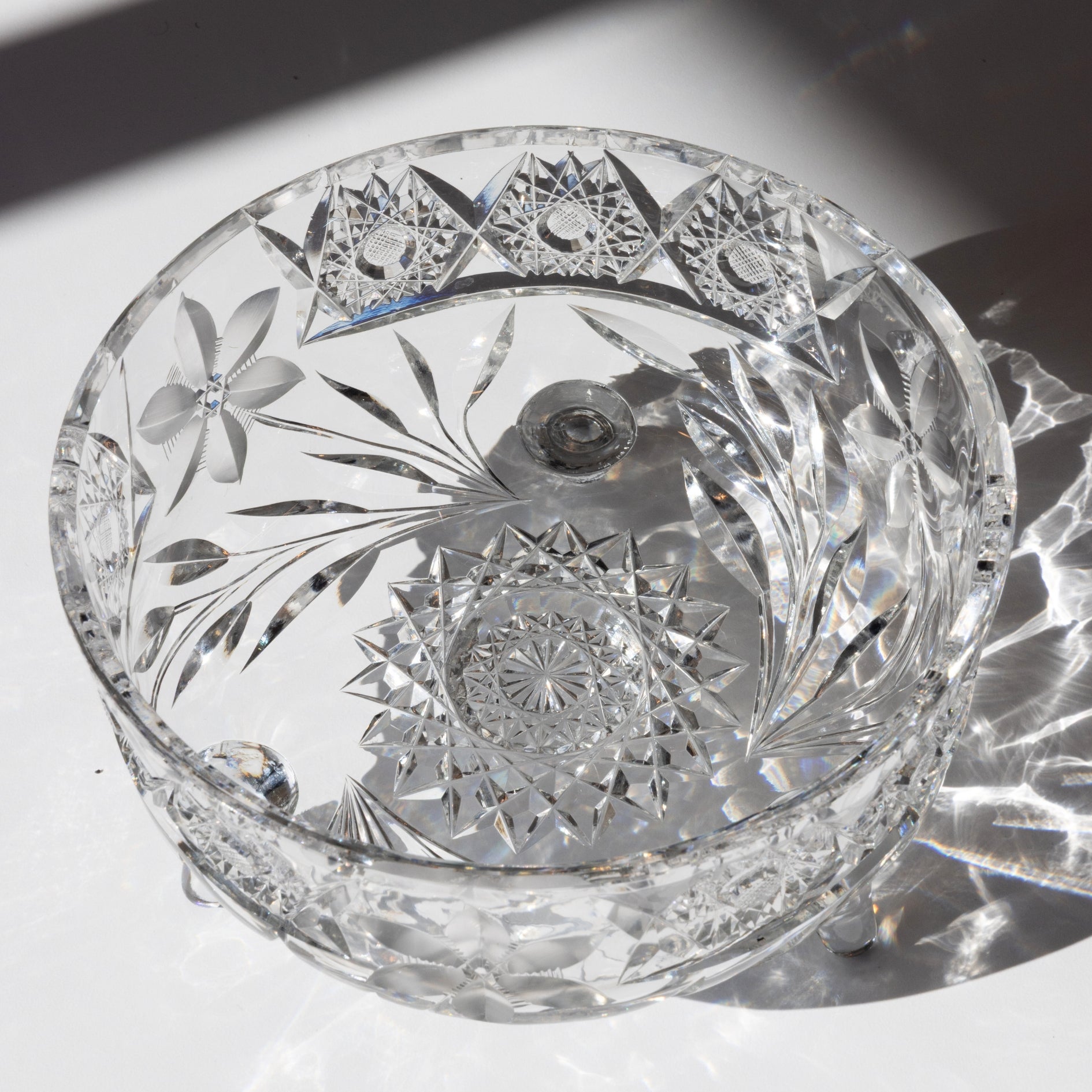 Cut crystal bowl with intricate designs on a reflective surface