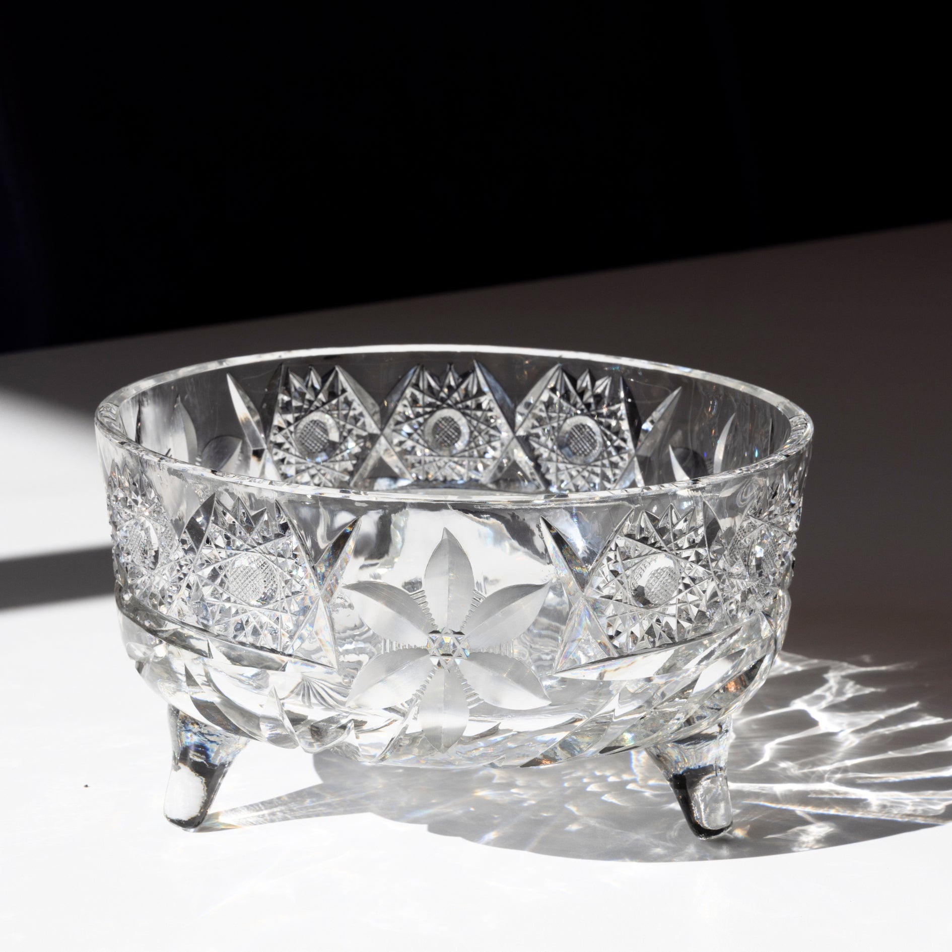 Crystal bowl with intricate cut patterns on a reflective surface