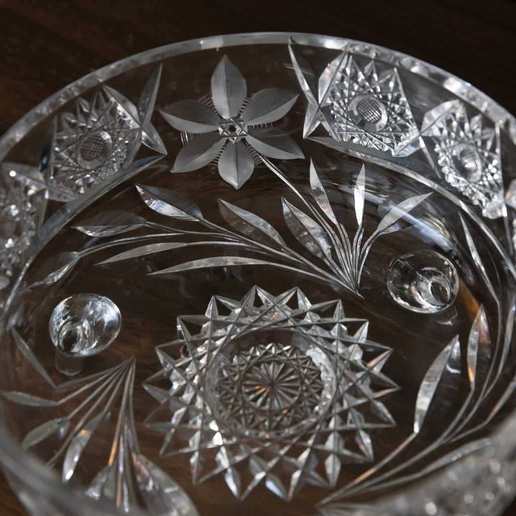 Close-up of a crystal dish with intricate floral and geometric patterns.