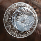Decorative clear glass bowl with intricate cut patterns on a brown surface