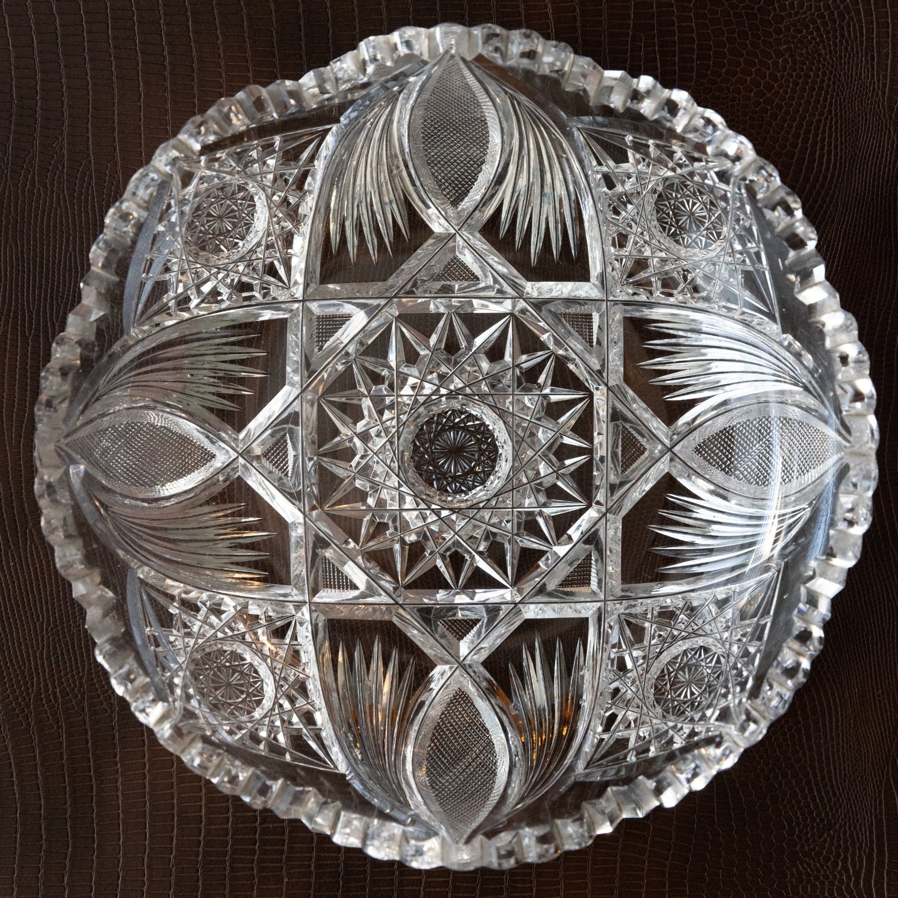 Decorative crystal plate with intricate cut patterns on a dark background