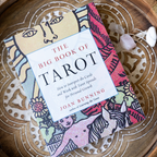 Book titled 'The Big Book of Tarot' by Joan Bunning on a decorative wooden surface.